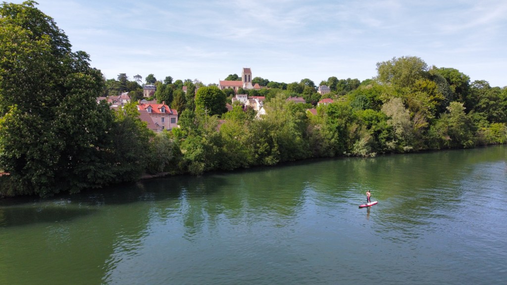 Stand up paddle à Auvers-sur-Oise, avec en fond l'église d'Auvers rendue célèbre par Van Gogh